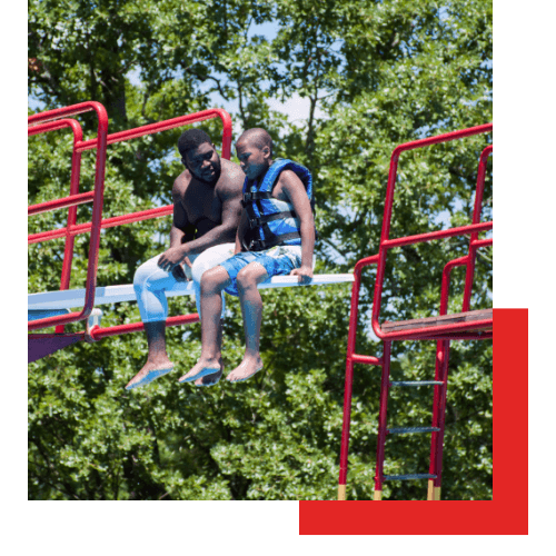 Young boy receiving adult support at summer camp with Kids Across America